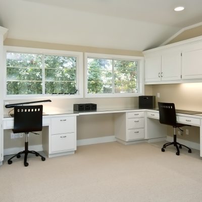 large home office area, three work areas with cabinets and book shelves, two large windows