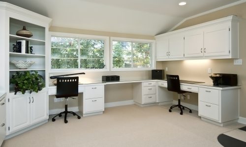large home office area, three work areas with cabinets and book shelves, two large windows
